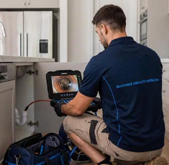 Plumber clearing a blocked toilet in a Rozelle bathroom